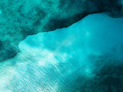 An overhead view of the changing turquoise tones of the sea in Cancún