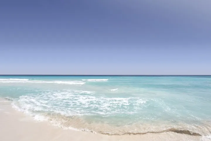 Turquoise waves washing onto the sand at a beach in Cancún